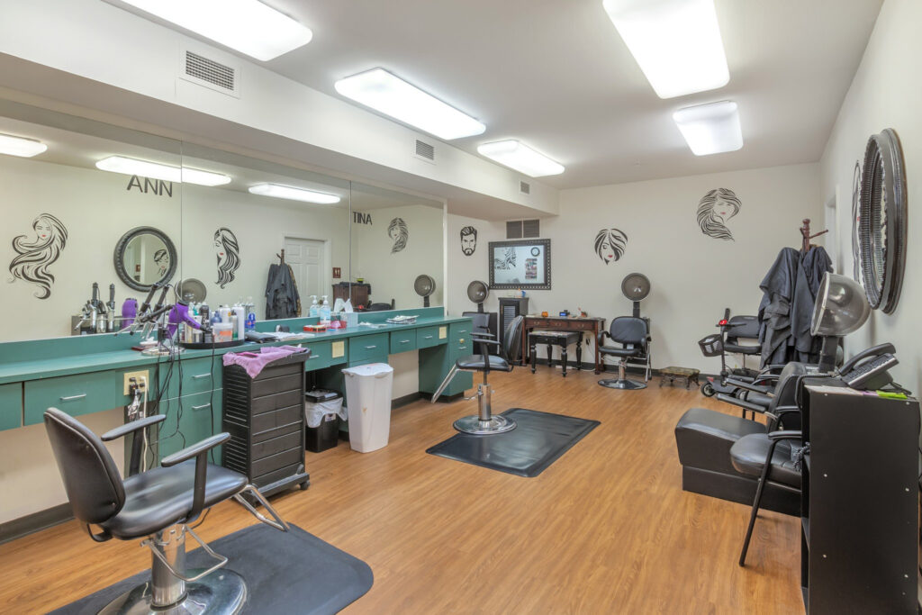 A beauty salon with mirrors, hair tools, and black chairs at Town Village Tulsa, a senior living community near Broken Arrow offering independent living.
